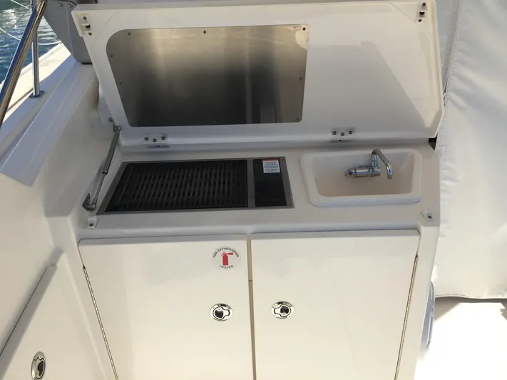  Yacht Photos Pics 2015 Pursuit SC 365i Sport Coupe outdoor kitchenette with sink and grill.