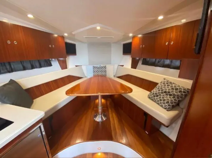  Yacht Photos Pics Luxurious interior of 2015 Pursuit SC 365i Sport Coupe with wood finishes and seating.