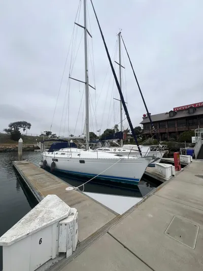 Alpha Carina Yacht Photos Pics 1993 Beneteau Oceanis 440 sailboat docked at marina on a cloudy day.