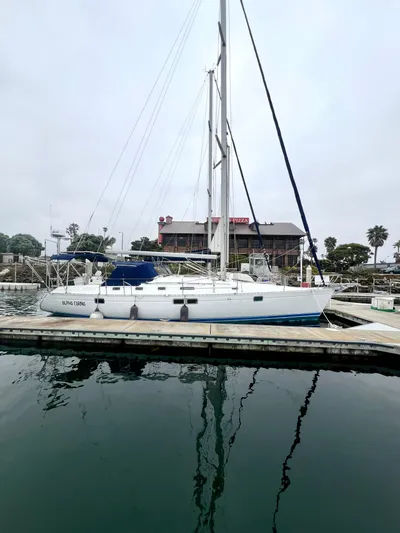 Alpha Carina Yacht Photos Pics 1993 Beneteau Oceanis 440 sailboat docked at a marina with calm waters.