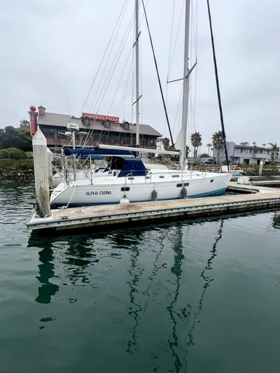 Alpha Carina Yacht Photos Pics 1993 Beneteau Oceanis 440 sailboat docked in a marina, overcast sky.