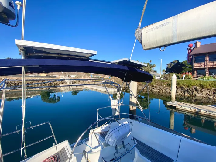 Alpha Carina Yacht Photos Pics Beneteau Oceanis 440 sailboat, 1993 model, docked in a serene marina under clear blue skies.