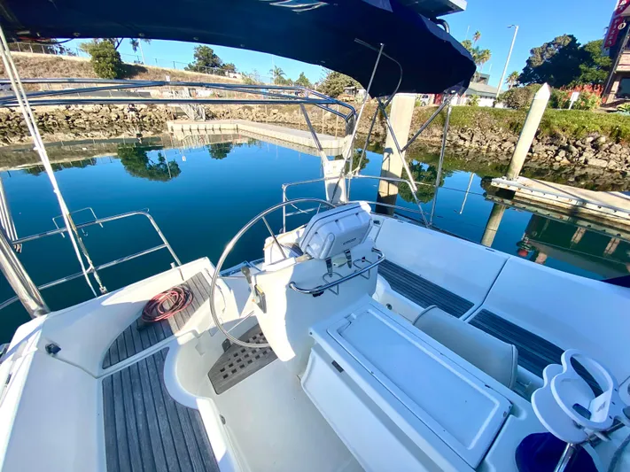 Alpha Carina Yacht Photos Pics Cockpit of 1993 Beneteau Oceanis 440 sailboat docked in a serene marina.