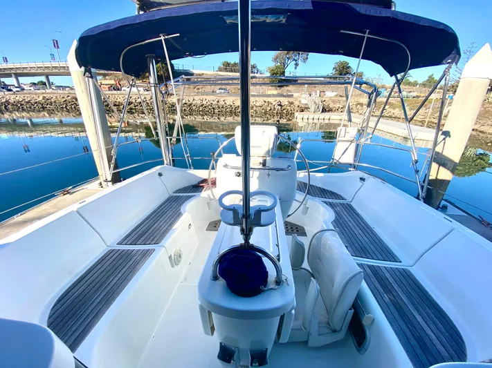 Alpha Carina Yacht Photos Pics Cockpit view of 1993 Beneteau Oceanis 440 sailboat docked by calm waters.