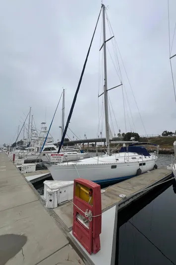 Alpha Carina Yacht Photos Pics 1993 Beneteau Oceanis 440 sailboat docked at marina on a cloudy day.