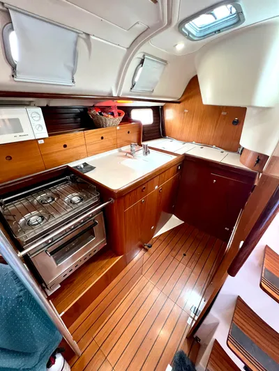 Alpha Carina Yacht Photos Pics Interior of 1993 Beneteau Oceanis 440 yacht with wooden cabinetry and modern kitchen amenities.