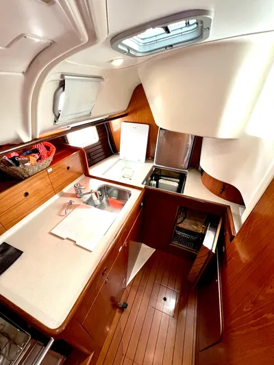 Alpha Carina Yacht Photos Pics 1993 Beneteau Oceanis 440 yacht kitchen with wood cabinetry and modern appliances.