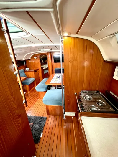 Alpha Carina Yacht Photos Pics Interior of 1993 Beneteau Oceanis 440 sailboat with wood finish and cozy seating area.