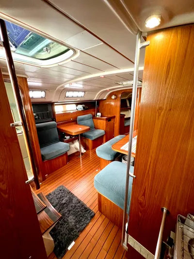 Alpha Carina Yacht Photos Pics Interior of 1993 Beneteau Oceanis 440 sailboat with wood finish and blue seating.