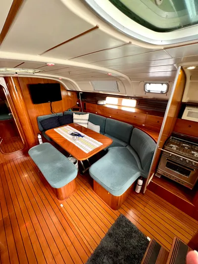 Alpha Carina Yacht Photos Pics Interior of 1993 Beneteau Oceanis 440 sailboat with cozy seating and wooden flooring.