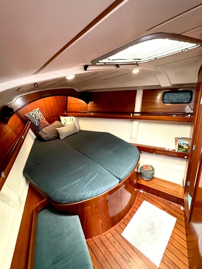 Alpha Carina Yacht Photos Pics Cozy cabin interior of 1993 Beneteau Oceanis 440 sailboat with wood finish and comfortable bedding.