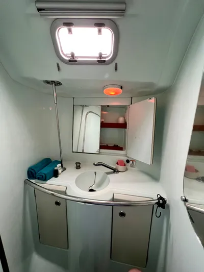 Alpha Carina Yacht Photos Pics Bathroom interior of 1993 Beneteau Oceanis 440 yacht, featuring sink, mirror, and storage cabinets.