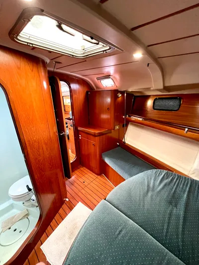 Alpha Carina Yacht Photos Pics Interior of 1993 Beneteau Oceanis 440 sailboat with wood finish and cozy seating area.
