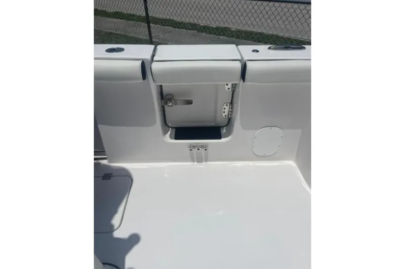  Yacht Photos Pics 2023 Tidewater 292 CC Adventure boat interior, featuring a sleek white deck and storage compartment.