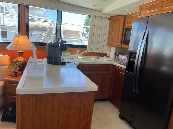  Yacht Photos Pics Interior of 1995 Viking Sports Yacht kitchen with modern appliances and wooden cabinetry.