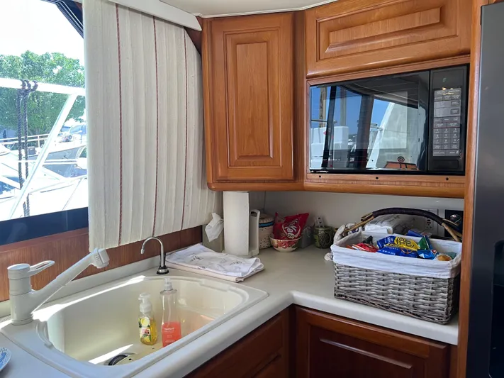  Yacht Photos Pics Interior of 1995 Viking Sports Yacht kitchen with sink, microwave, and snack basket.