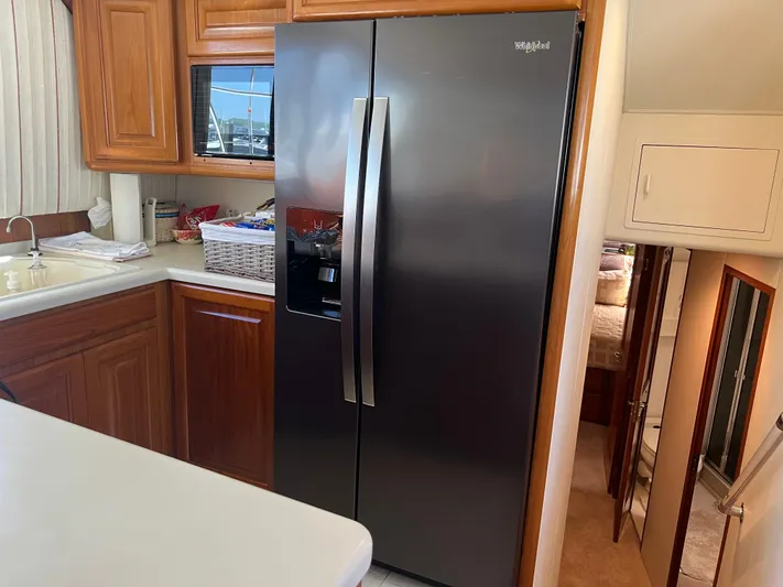  Yacht Photos Pics Kitchen area of a 1995 Viking Sports Yacht with modern appliances and wooden cabinetry.