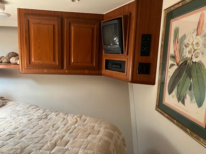  Yacht Photos Pics Interior of 1995 Viking Sports Yacht with wood cabinets, vintage TV, and floral artwork.