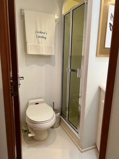  Yacht Photos Pics Bathroom in 1995 Viking Sports Yacht with shower, toilet, and towel labeled "Lockan's Landing."