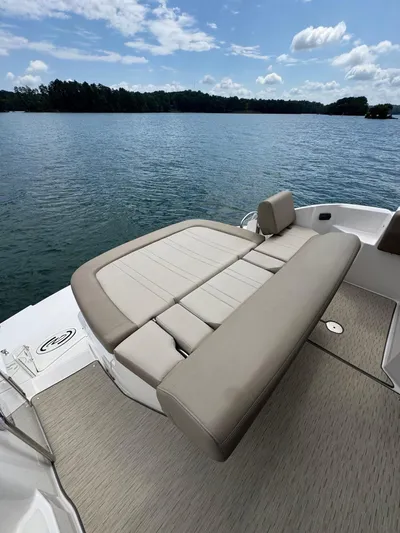 Lake Break Yacht Photos Pics 2016 Regal 42 Sport Coupe boat with cushioned seating, on a serene lake.