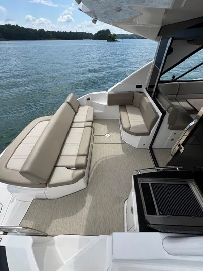 Lake Break Yacht Photos Pics 2016 Regal 42 Sport Coupe yacht interior with beige seating, overlooking serene water.