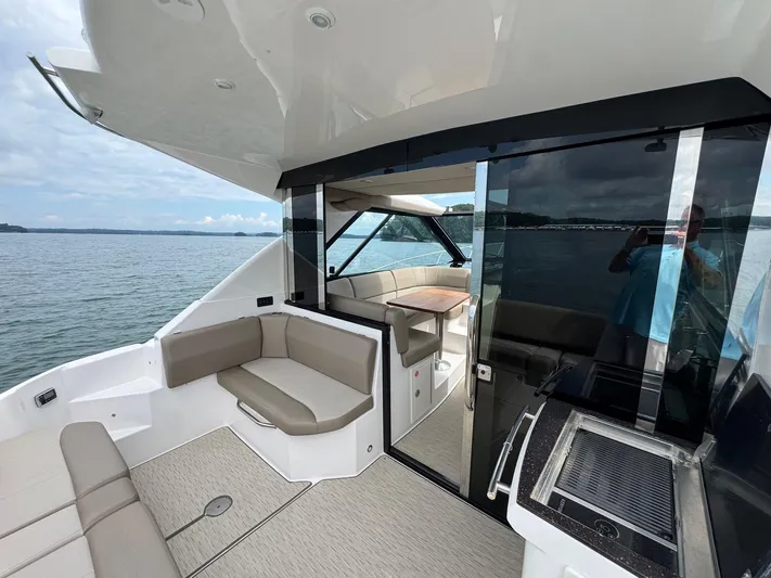 Lake Break Yacht Photos Pics 2016 Regal 42 Sport Coupe yacht interior with seating and table, overlooking serene waters.