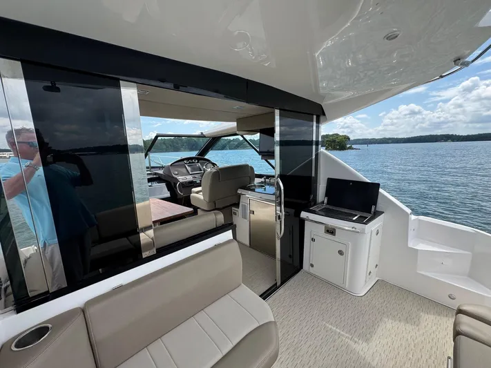 Lake Break Yacht Photos Pics 2016 Regal 42 Sport Coupe interior with seating, helm, and lake view.