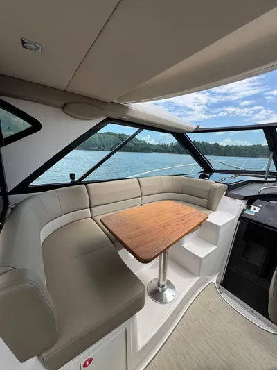 Lake Break Yacht Photos Pics Interior of 2016 Regal 42 Sport Coupe with seating and wooden table, overlooking water.