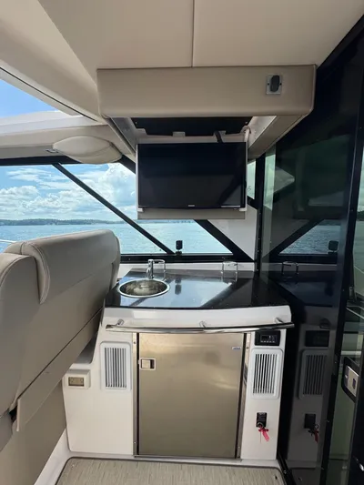 Lake Break Yacht Photos Pics Interior of 2016 Regal 42 Sport Coupe yacht with kitchenette and TV, overlooking the ocean.