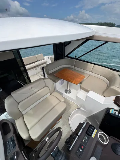 Lake Break Yacht Photos Pics 2016 Regal 42 Sport Coupe interior with seating and table, overlooking water.