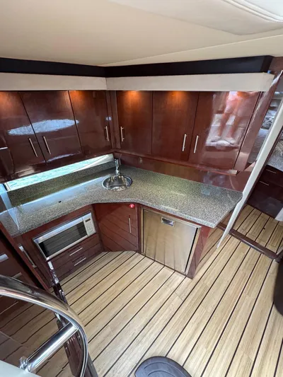 Lake Break Yacht Photos Pics Luxurious kitchen interior of 2016 Regal 42 Sport Coupe with wood cabinets and modern appliances.