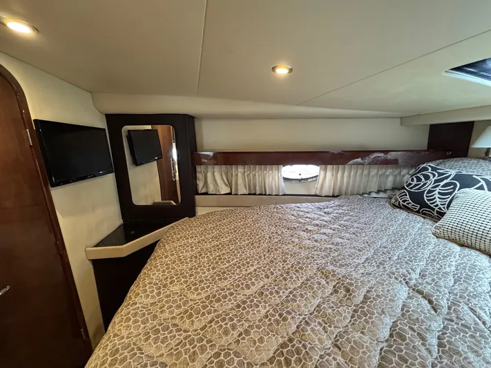 Lake Break Yacht Photos Pics 2016 Regal 42 Sport Coupe cabin interior with bed, TV, and window.