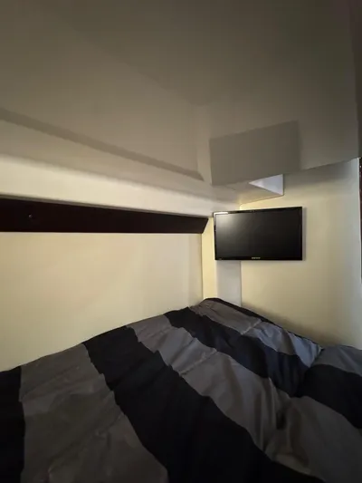 Lake Break Yacht Photos Pics Cozy cabin interior of 2016 Regal 42 Sport Coupe with TV and striped bedding.