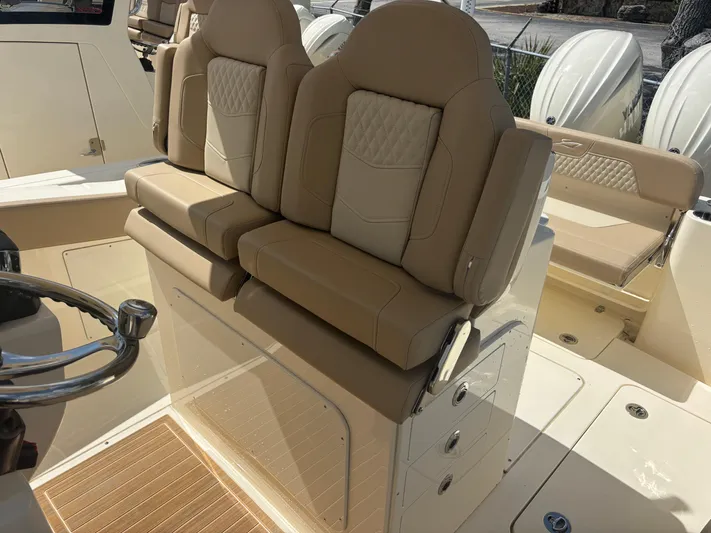  Yacht Photos Pics 2025 Scout 277 LXF boat interior with beige leather seating and steering wheel.