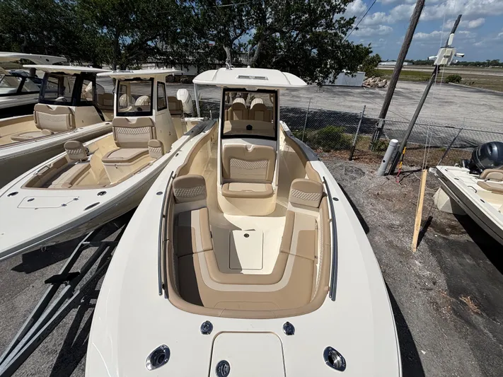  Yacht Photos Pics 2025 Scout 277 LXF boat with beige interior, docked outdoors under a clear sky.