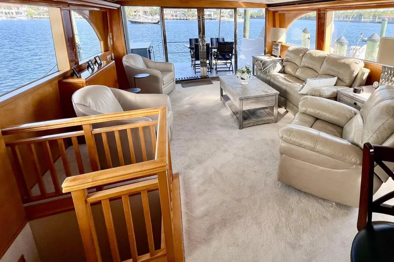Kristin Lee Yacht Photos Pics Luxurious interior of 2001 Hatteras 75 Cockpit Motor Yacht with plush seating and scenic water views.