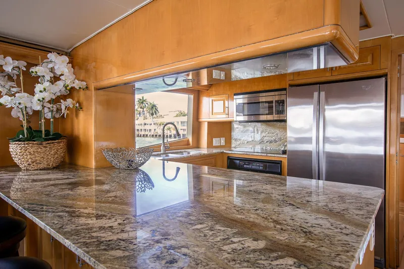 Kristin Lee Yacht Photos Pics Luxurious kitchen interior of 2001 Hatteras 75 Cockpit Motor Yacht with granite countertops.