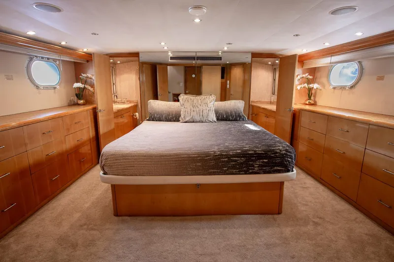 Kristin Lee Yacht Photos Pics Luxurious bedroom interior of 2001 Hatteras 75 Cockpit Motor Yacht with elegant wood cabinetry.