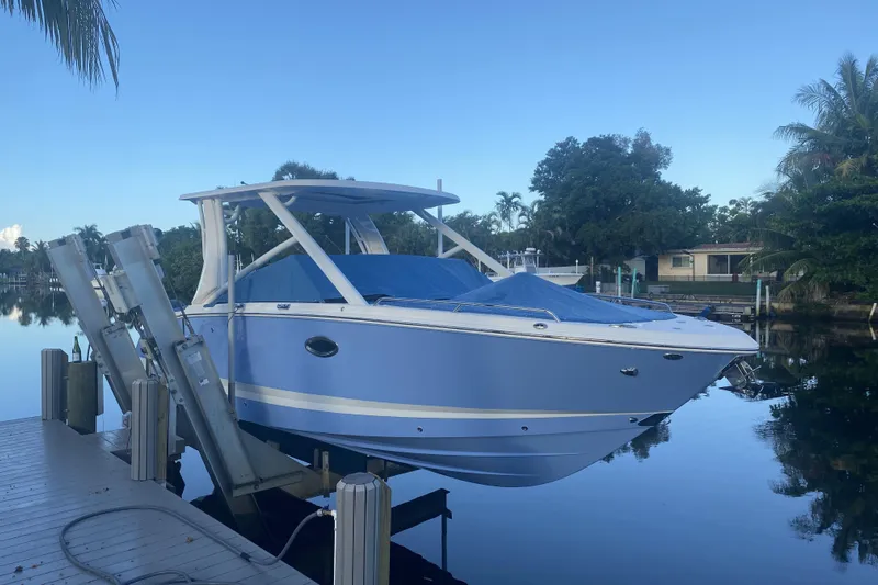  Yacht Photos Pics 2022 Chaparral 280 OSX boat docked on a serene waterfront.