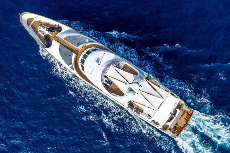  Yacht Photos Pics Aerial view of a luxurious 2002 CMN Custom yacht cruising through deep blue ocean waters.