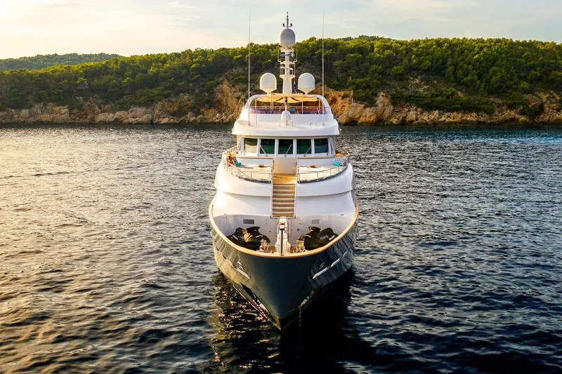  Yacht Photos Pics Luxurious 2002 CMN Custom yacht on serene water with lush green coastline.