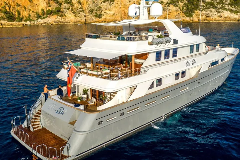  Yacht Photos Pics Luxurious 2002 CMN Custom yacht cruising in clear blue waters near rocky coastline.