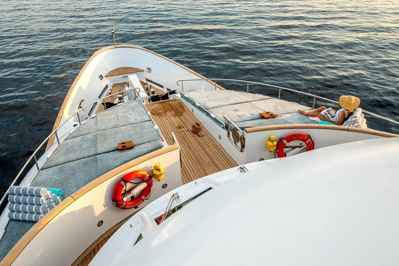  Yacht Photos Pics Luxury yacht deck with sunbathing area, person relaxing, CMN Custom 2002 model.