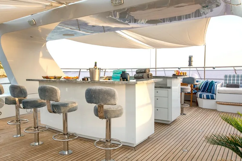  Yacht Photos Pics Luxurious yacht deck with bar stools, elegant seating, and ocean view, CMN Custom 2002 model.