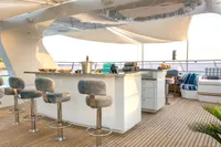 Luxurious yacht deck with bar stools, elegant seating, and ocean view, CMN Custom 2002 model.