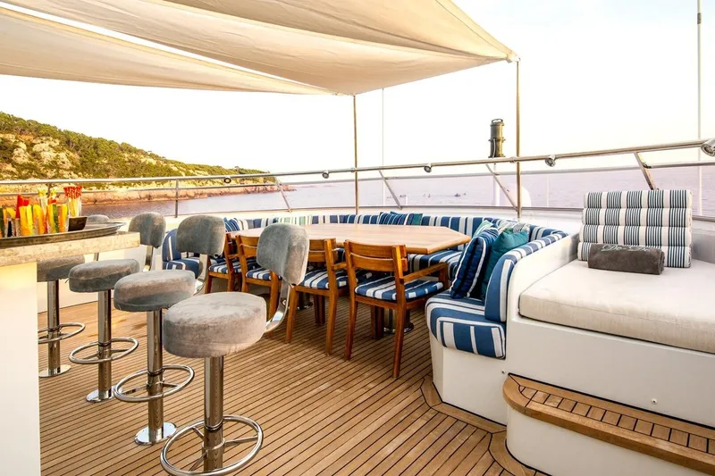  Yacht Photos Pics Luxurious yacht deck with seating, bar stools, and ocean view, CMN Custom 2002 model.