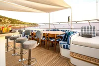 Luxurious yacht deck with seating, bar stools, and ocean view, CMN Custom 2002 model.