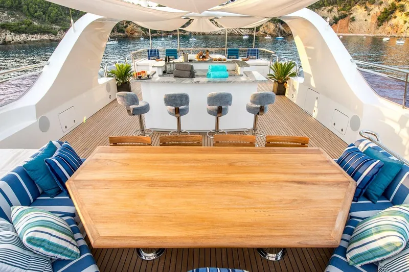  Yacht Photos Pics Luxurious yacht deck with seating, bar stools, and scenic ocean view, CMN Custom 2002 model.