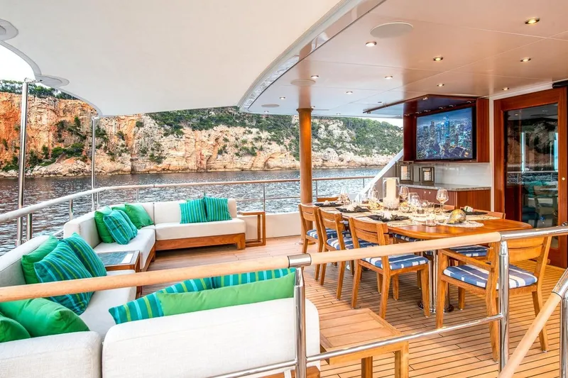  Yacht Photos Pics Luxurious yacht deck with dining area, scenic coastal view, CMN Custom 2002 model.