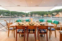 Luxurious yacht dining setup with ocean view, featuring elegant tableware and comfortable seating.